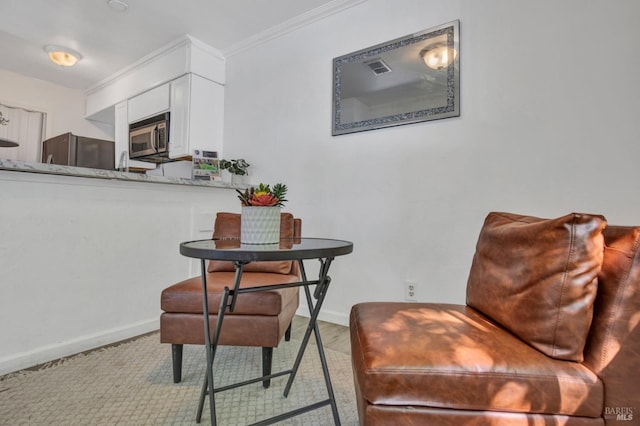 interior space with stone counters, ornamental molding, white cabinetry, stainless steel appliances, and baseboards