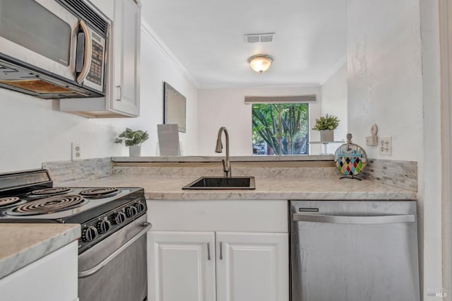 kitchen featuring a sink, ornamental molding, appliances with stainless steel finishes, and visible vents
