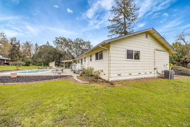 rear view of property with crawl space, an outdoor pool, a patio area, and a yard