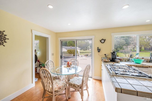 dining space with baseboards, recessed lighting, and light wood finished floors