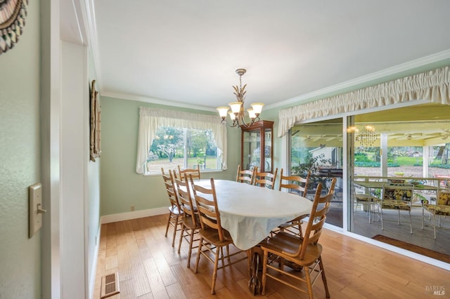 dining room with baseboards, crown molding, a chandelier, and light wood-type flooring