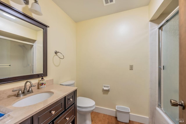 bathroom featuring vanity, toilet, baseboards, visible vents, and wood finished floors