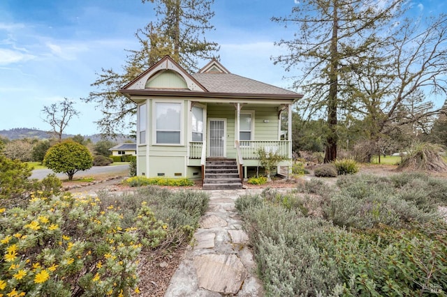 view of front of home featuring a shingled roof and a porch