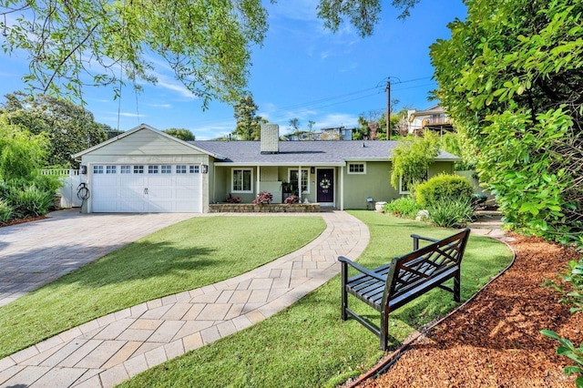 single story home featuring driveway, a chimney, a garage, and a front yard