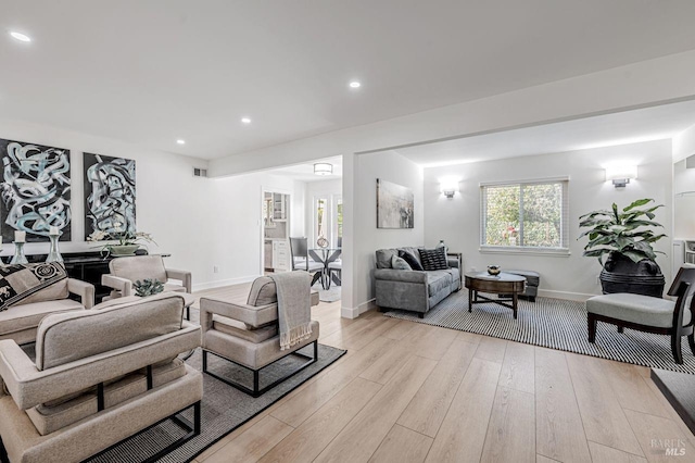 living room featuring light wood-style flooring, baseboards, and recessed lighting
