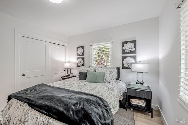 bedroom with baseboards, a closet, and wood finished floors