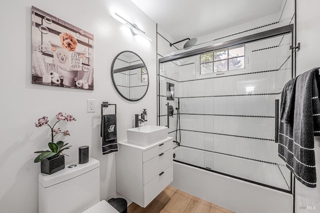 full bathroom with toilet, vanity, enclosed tub / shower combo, and wood finished floors