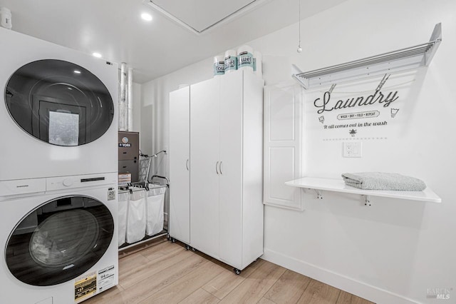 clothes washing area with stacked washer / drying machine, laundry area, baseboards, light wood-style floors, and recessed lighting