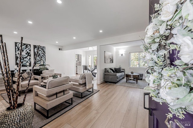 living room with baseboards, light wood-type flooring, and recessed lighting