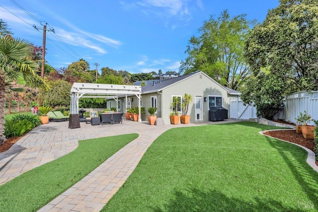 rear view of property with an outdoor hangout area, stucco siding, fence, a patio area, and a lawn