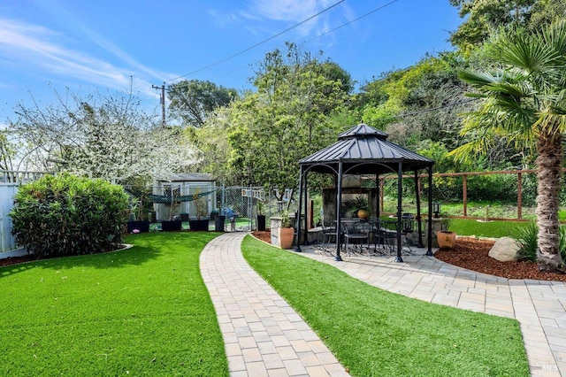 view of property's community featuring fence, a gazebo, a yard, and a patio area
