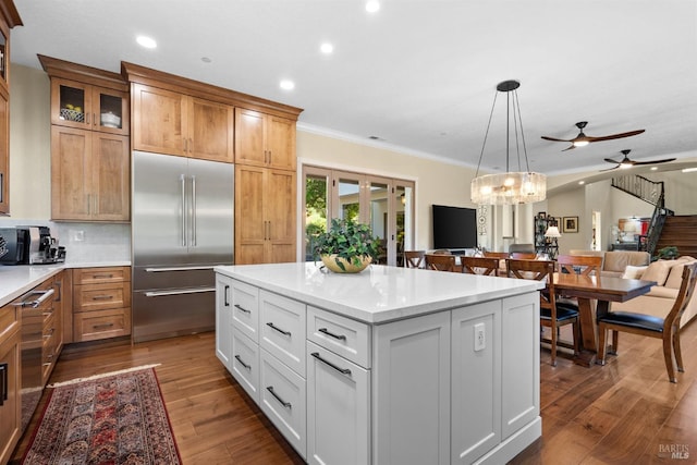 kitchen featuring a ceiling fan, open floor plan, stainless steel built in refrigerator, ornamental molding, and recessed lighting
