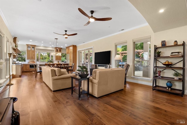 living room with crown molding, ceiling fan, wood-type flooring, visible vents, and recessed lighting