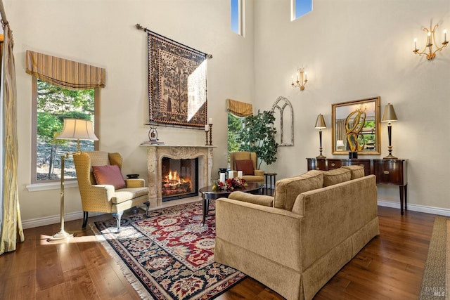 living area featuring a fireplace, hardwood / wood-style floors, and baseboards