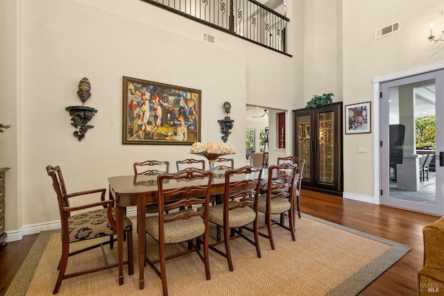 dining area featuring baseboards, wood finished floors, and visible vents