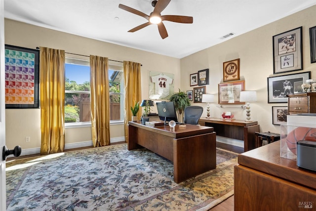 office space with baseboards, wood finished floors, visible vents, and ceiling fan