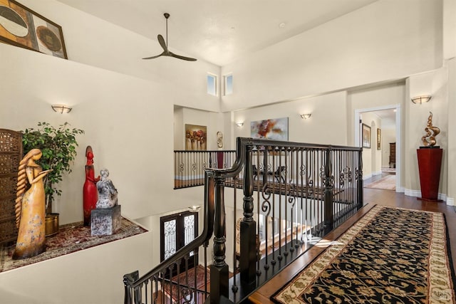 corridor featuring a high ceiling and an upstairs landing