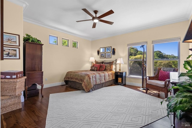 bedroom with dark wood-type flooring, crown molding, baseboards, and ceiling fan