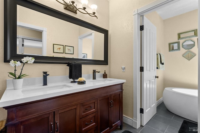 full bath featuring double vanity, a freestanding tub, tile patterned flooring, and a sink