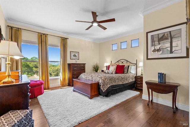 bedroom featuring wood-type flooring, a ceiling fan, baseboards, and ornamental molding