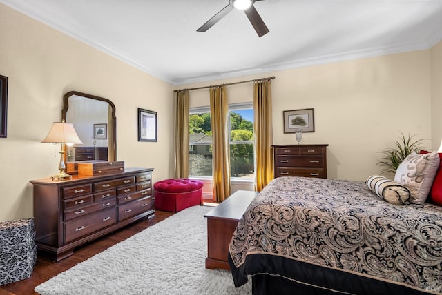 bedroom featuring dark wood-type flooring, ceiling fan, and crown molding