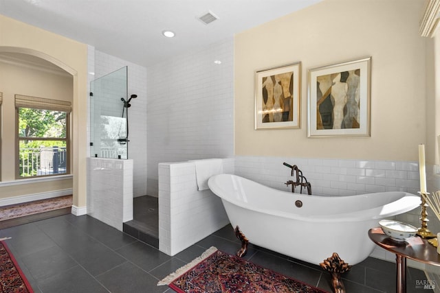 bathroom featuring a walk in shower, tile patterned floors, visible vents, and tile walls