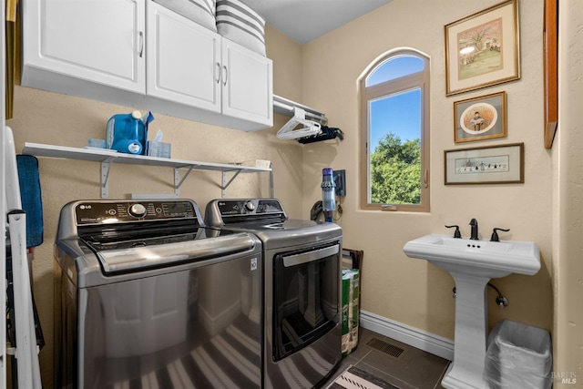 laundry area with washer and clothes dryer, tile patterned floors, cabinet space, baseboards, and visible vents