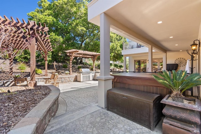 view of patio / terrace featuring a jacuzzi, a pergola, an outdoor kitchen, and a balcony