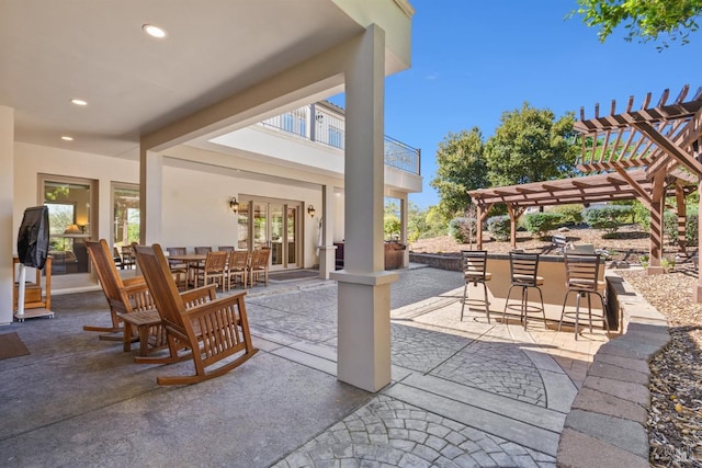 view of patio / terrace featuring a pergola, outdoor dry bar, and outdoor dining space