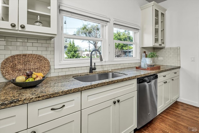 kitchen with dark stone counters, stainless steel dishwasher, white cabinetry, a sink, and dark wood-style floors