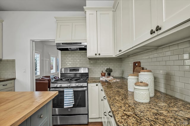 kitchen featuring stainless steel gas stove, tasteful backsplash, white cabinets, under cabinet range hood, and wood counters