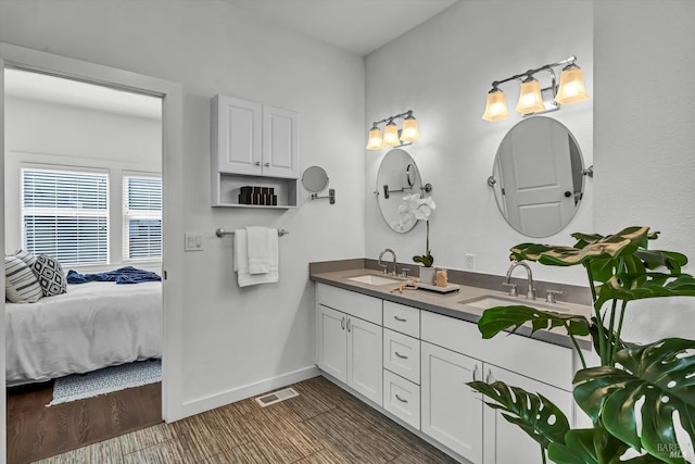 full bath with baseboards, wood finished floors, a sink, and visible vents