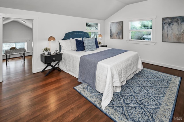 bedroom featuring baseboards, wood finished floors, and vaulted ceiling