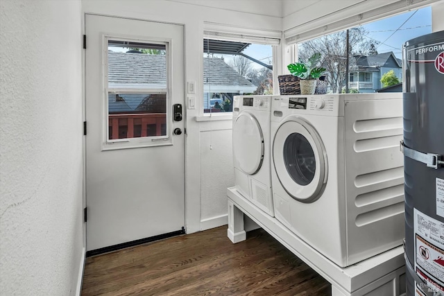 clothes washing area with laundry area, separate washer and dryer, dark wood-style flooring, a textured wall, and baseboards
