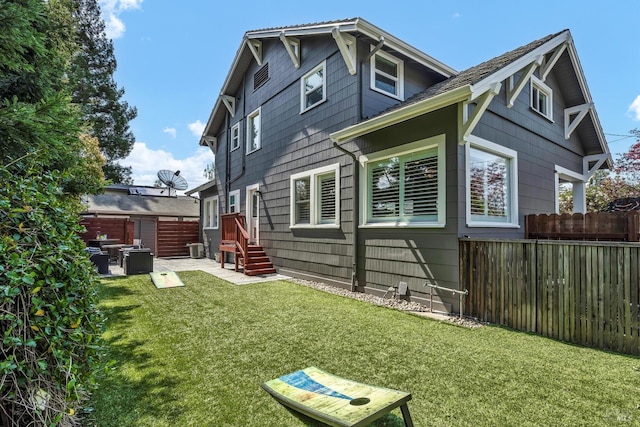 back of house with a yard, fence, and central AC unit