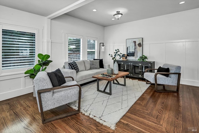 living room featuring recessed lighting, a decorative wall, and wood finished floors