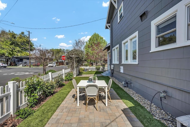 view of patio with outdoor dining area and fence