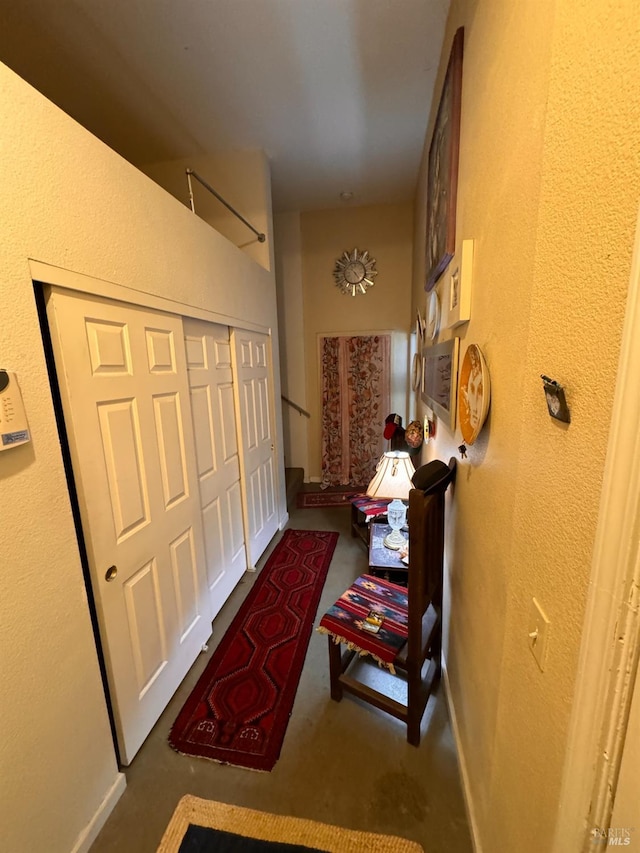 hallway with a textured wall and concrete flooring