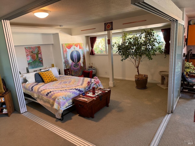 carpeted bedroom featuring baseboards, a textured ceiling, and multiple windows