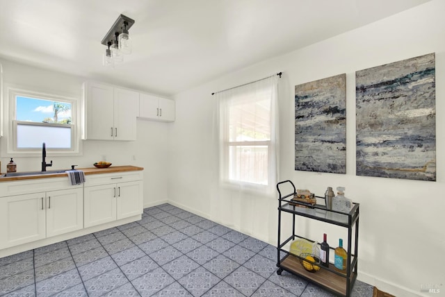 624 Annette Ave, Vallejo, CA 94591 - kitchen with a sink, wooden counters, white cabinetry, and baseboards