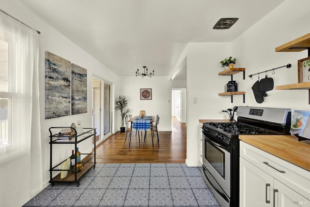 624 Annette Ave, Vallejo, CA 94591 - kitchen featuring stainless steel gas stove, open shelves, white cabinetry, butcher block countertops, and baseboards