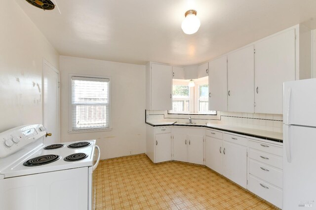 kitchen with white appliances, white cabinets, and light floors