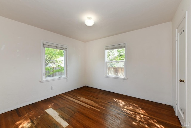 spare room with plenty of natural light and hardwood / wood-style flooring