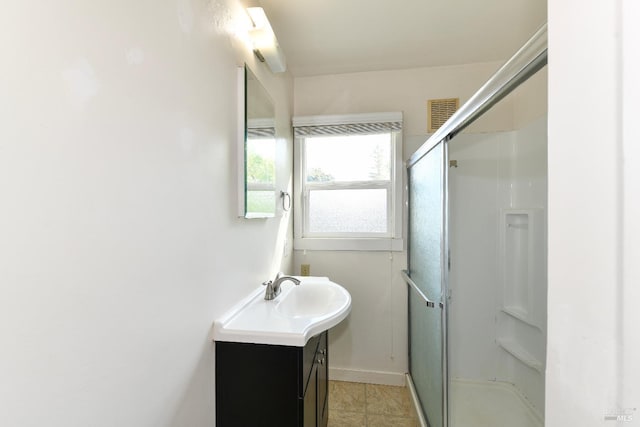 bathroom with vanity, baseboards, visible vents, and a shower stall