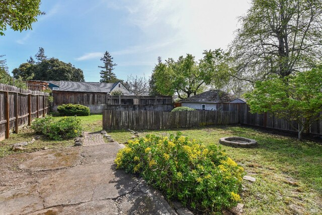 view of yard with a fire pit and a fenced backyard
