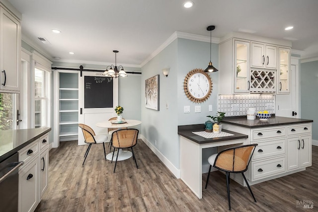 kitchen with dishwashing machine, crown molding, backsplash, and dark countertops