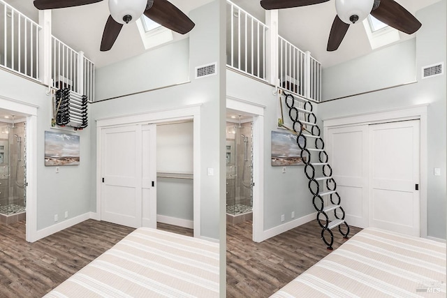 unfurnished bedroom with a towering ceiling, baseboards, visible vents, and a skylight