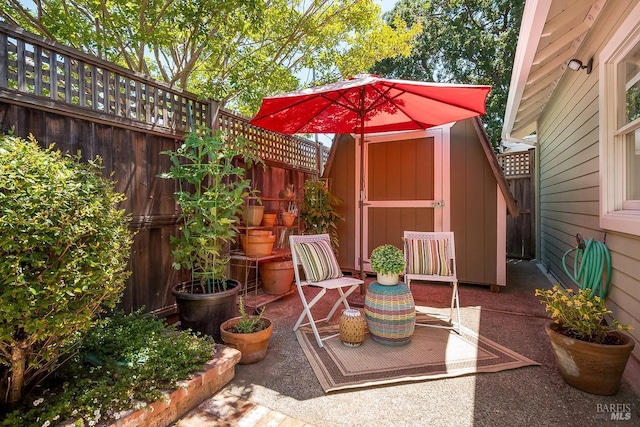 view of patio with a storage shed, a fenced backyard, and an outdoor structure