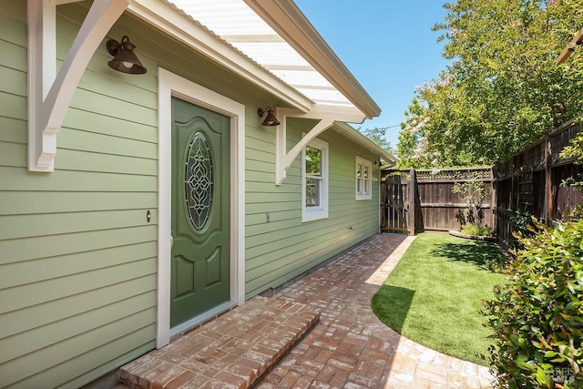 entrance to property with a yard and fence