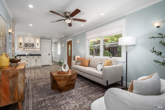 living room featuring recessed lighting, crown molding, indoor bar, and wood finished floors
